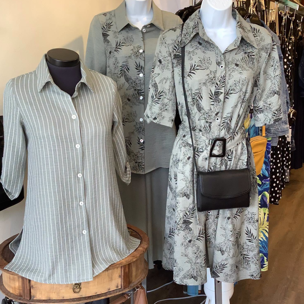 Three mannequin busts with grey and white outfits on