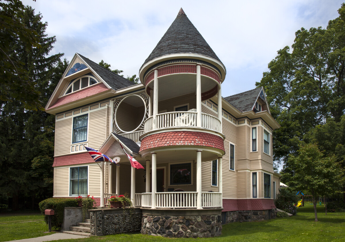 Home with vintage architecture including a two-storey open turret and columned porch.
