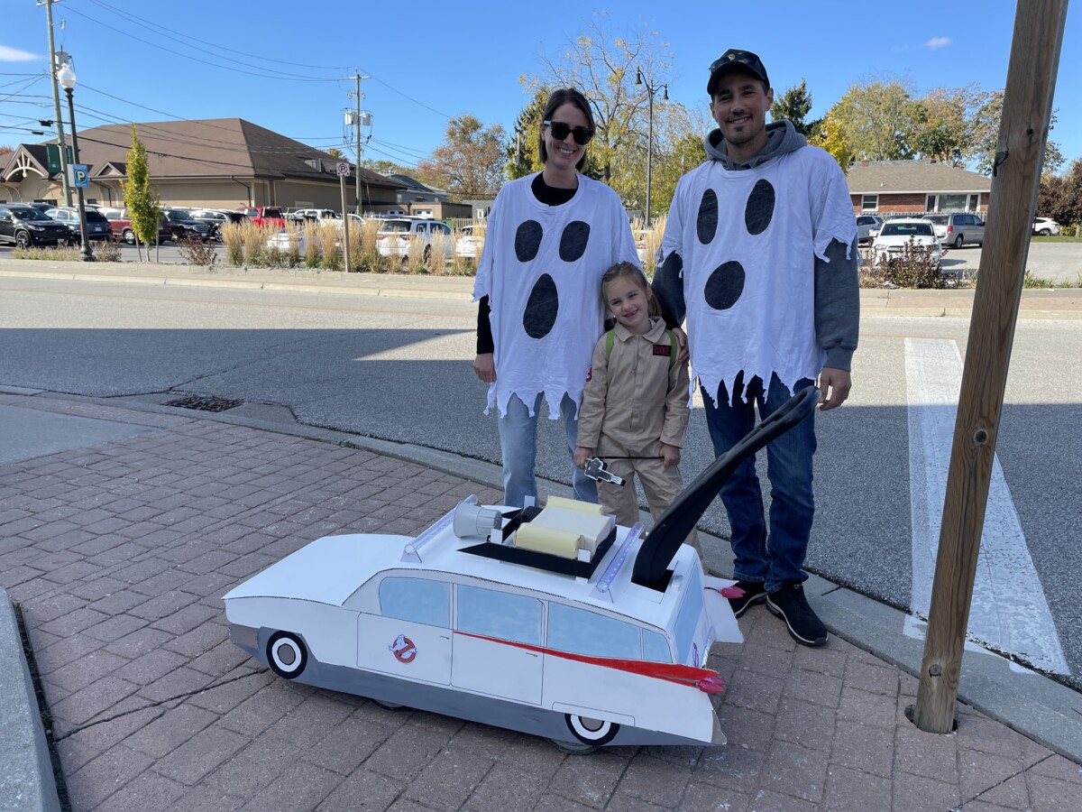 Family costume of Ghostbusters enjoy a trick or treat event downtown.