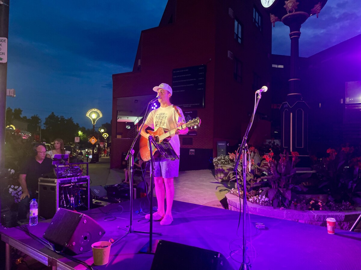 A performer on an outdoor stage in the late evening